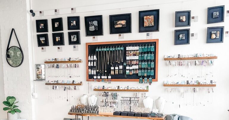 Gallery wall of framed mosaic art and a table of stone and gem jewerlry